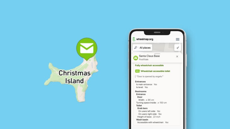 You can see a map view of Australia's Christmas Island on Wheelmap.org, a green pin with letter symbol sits at the top. Next to it is a smartphone screen with the location details. The location is called "Santa Claus Base." Below that, wheelchair accessibility details are listed.